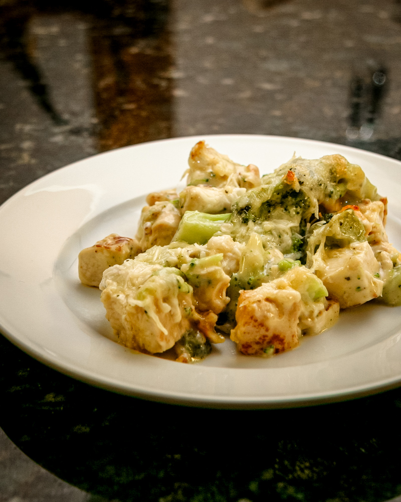 A serving of chicken and broccoli casserole on a white plate.