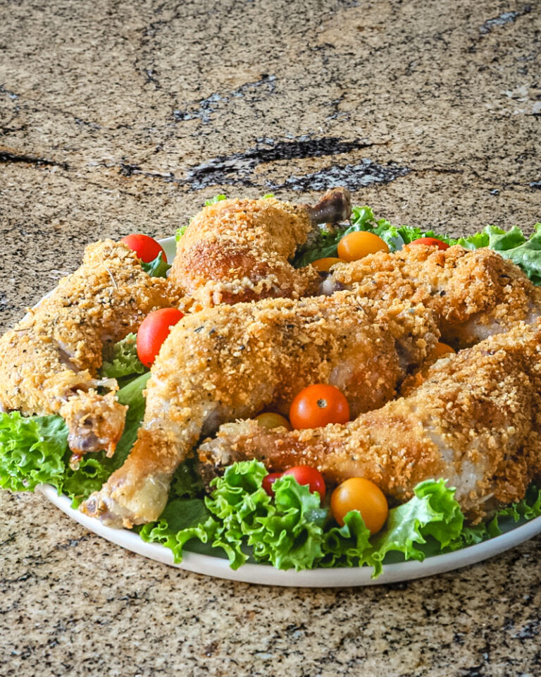 Cornflake crusted chicken on a platter with tomatoes and lettuce.