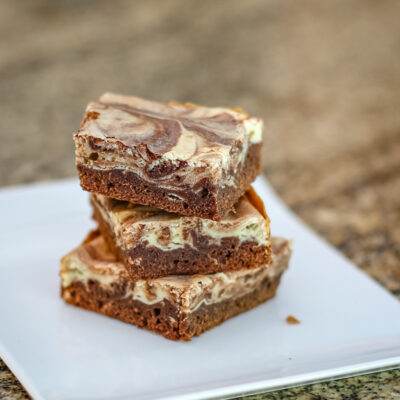 chocolate and cream cheese swirl brownies on a white plate