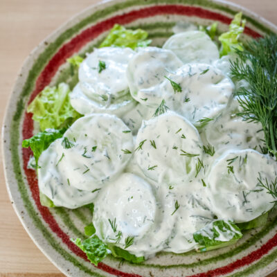 cucumber salad with sour cream and dill on a colorful plate