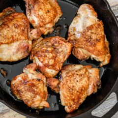 crispy skin chicken thighs in an iron skillet