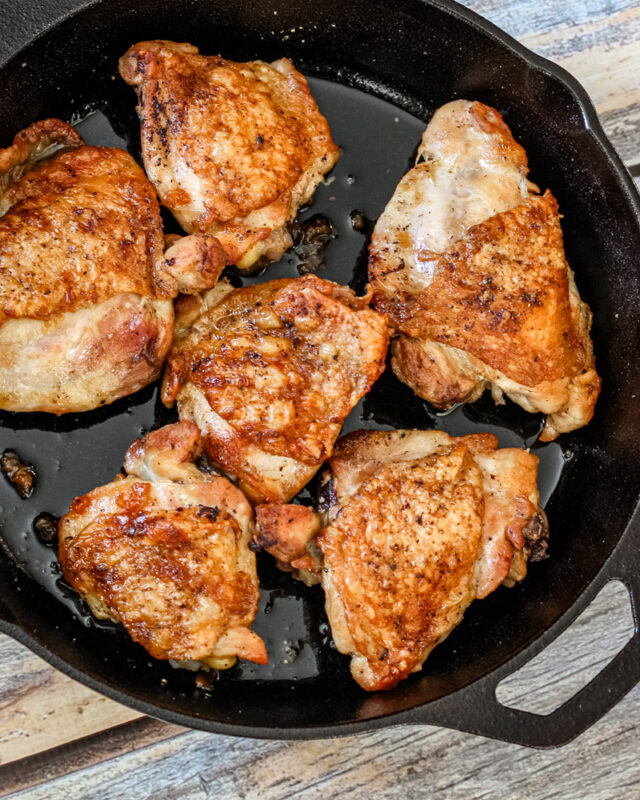 crispy skin chicken thighs in an iron skillet