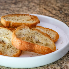 Simple seasoned crostini on a white plate