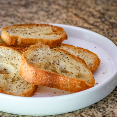 Simple seasoned crostini on a white plate