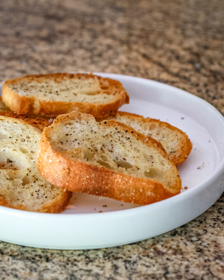 Simple seasoned crostini on a white plate