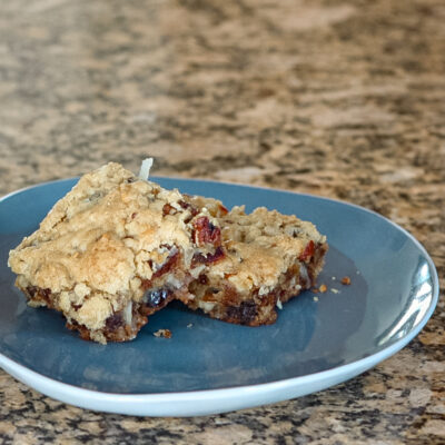 Date coconut blondies on a blue and white plate.