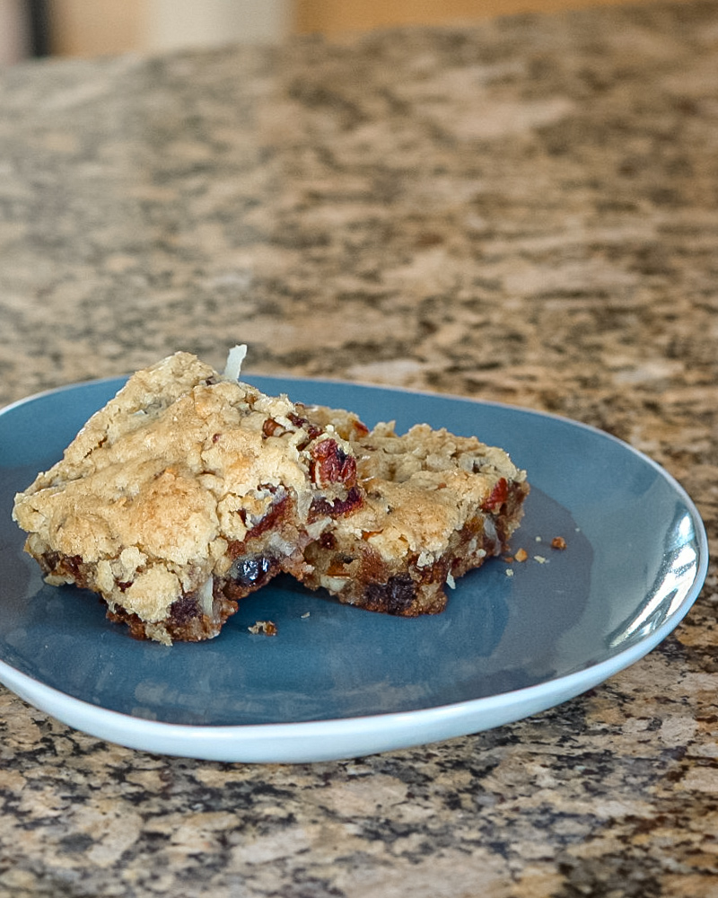 Date coconut blondies on a blue and white plate.