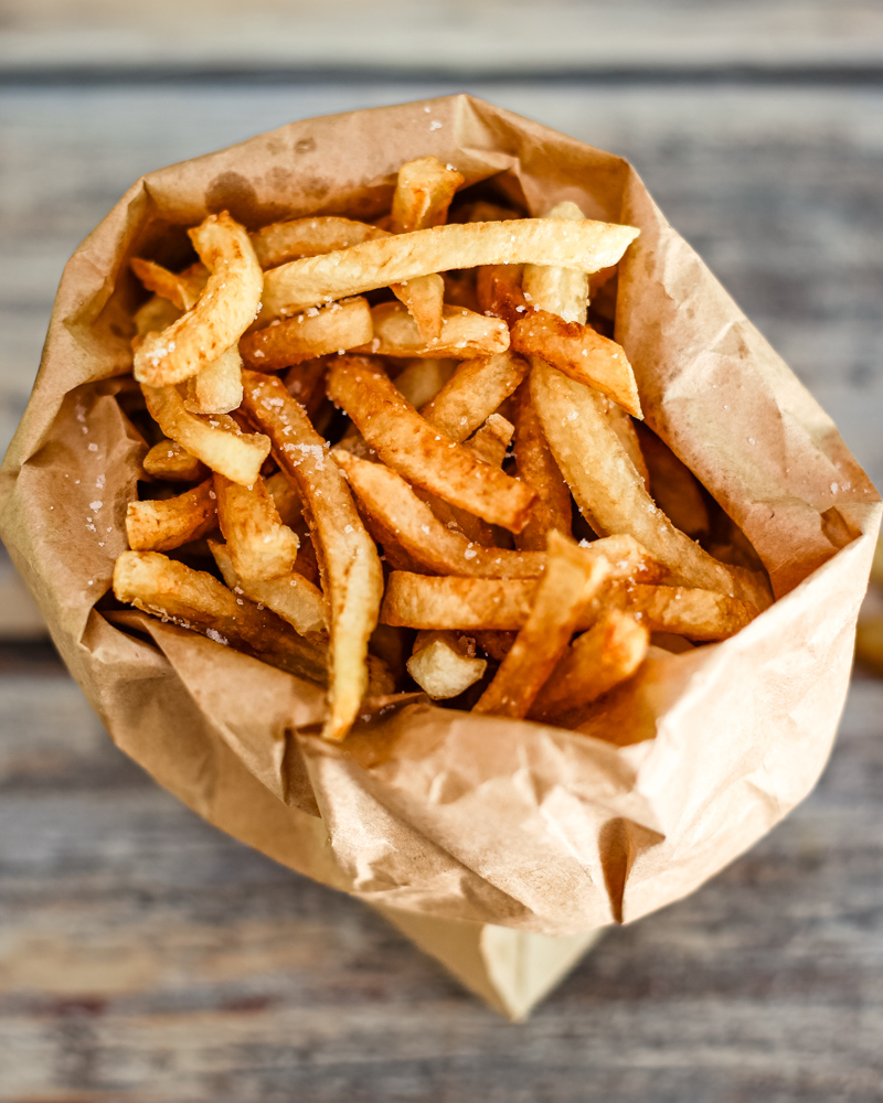 deep fried french fries in a paper bag
