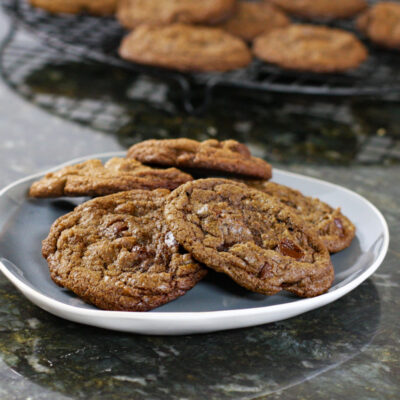 Cookies on a blue and white plate with more cookies in the background.