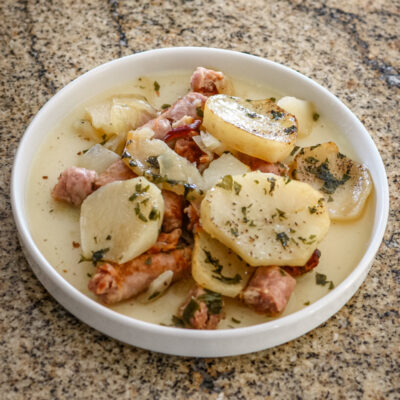 A plate of dublin coddle, potatoes and sausages
