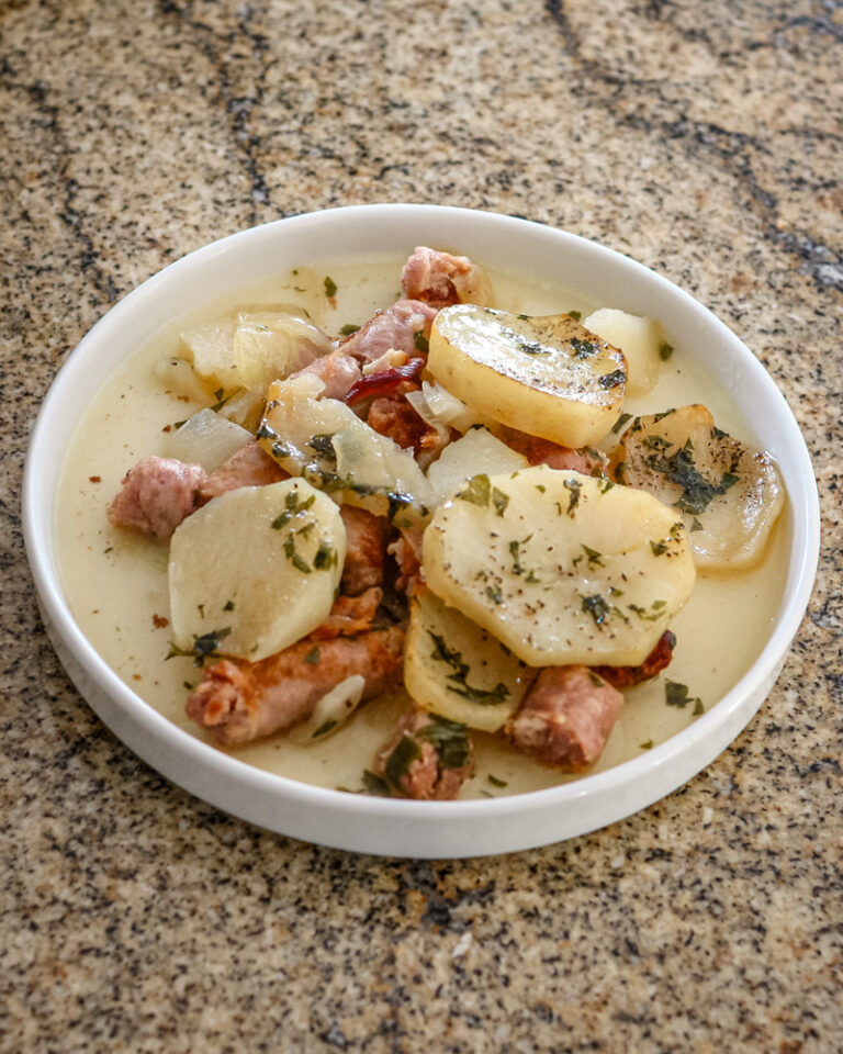 A plate of dublin coddle, potatoes and sausages