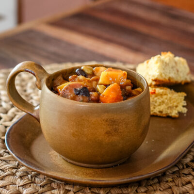 baked beans with butternut squash and smoked sausage on a plate with cornbread