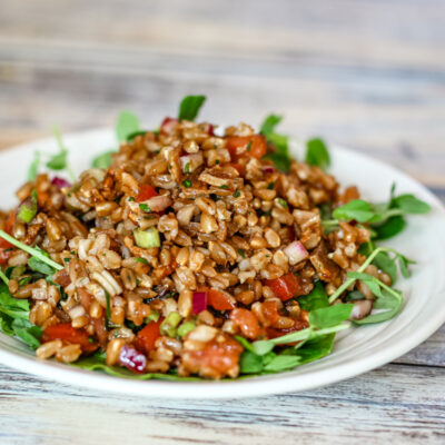 farro salad with tomatoes on a plate with pea shoots