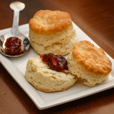 Flaky buttermilk biscuits on a plate with jam