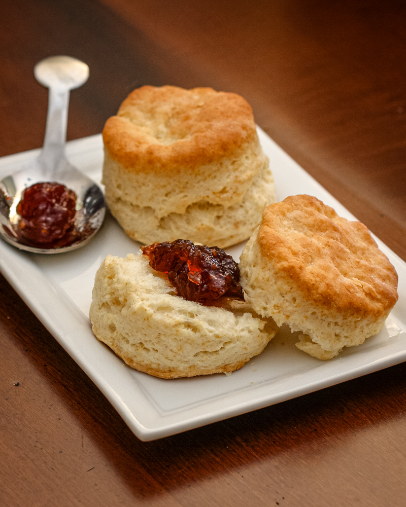 Flaky buttermilk biscuits on a plate with jam