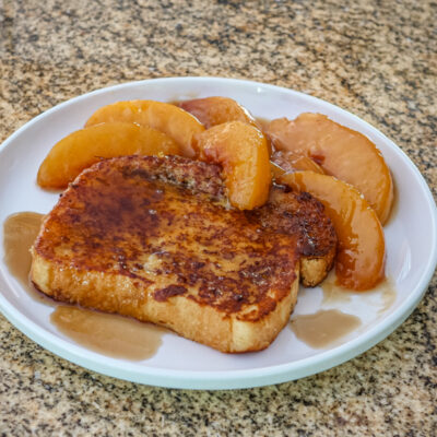 french toast on a plate with caramelized peaches