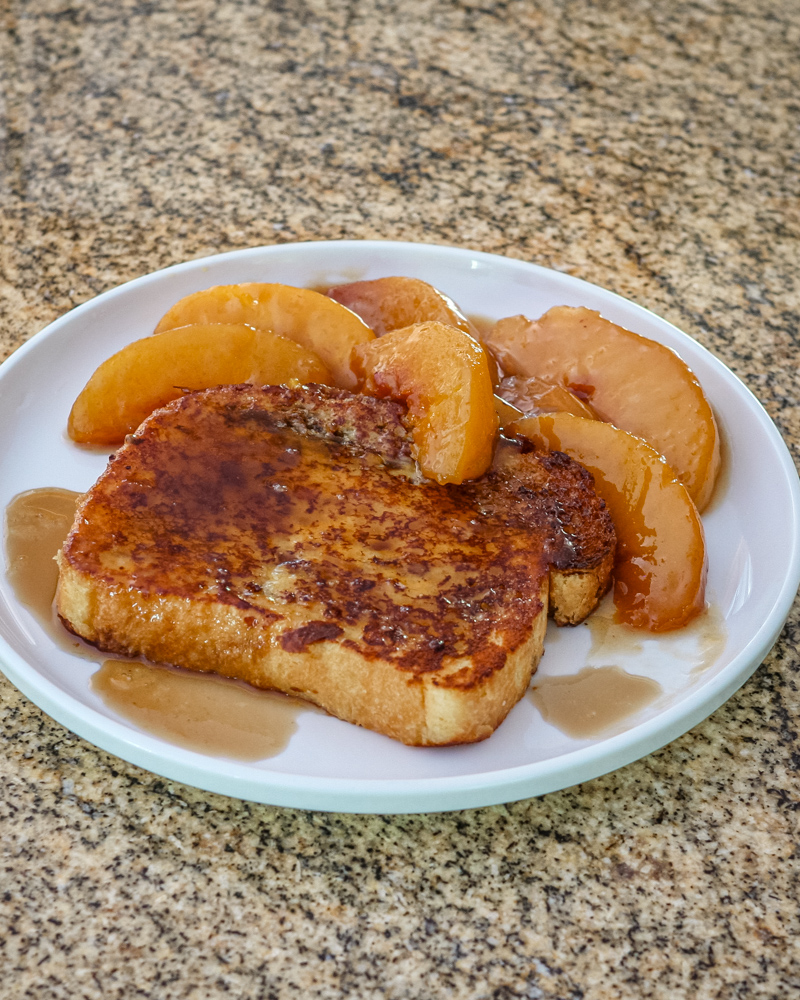 french toast on a plate with caramelized peaches