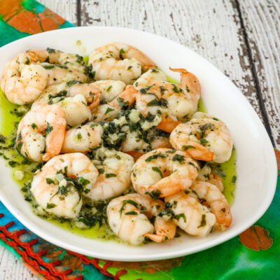 Garlic butter shrimp on a plate with parsley.