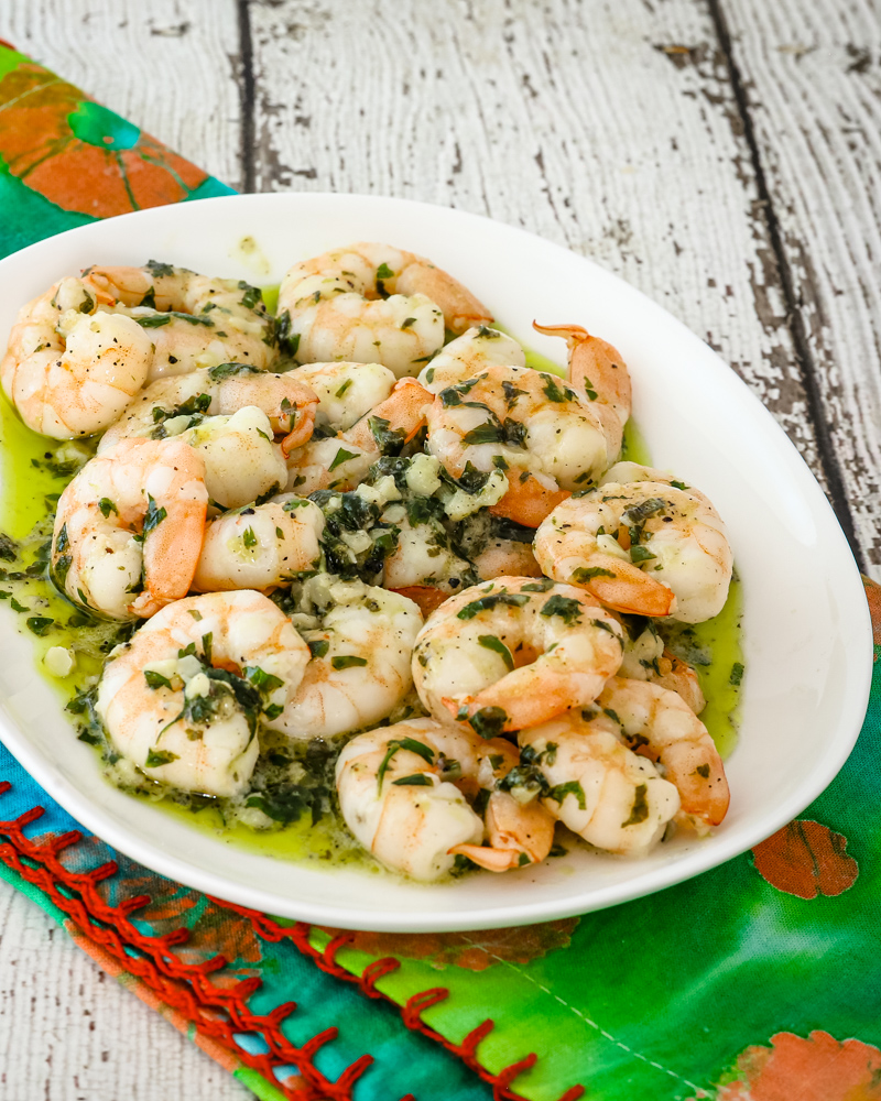 Garlic butter shrimp on a plate with parsley.