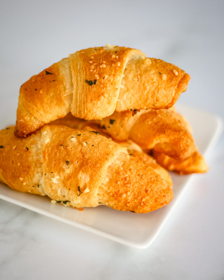 garlic butter crescent rolls on a white plate