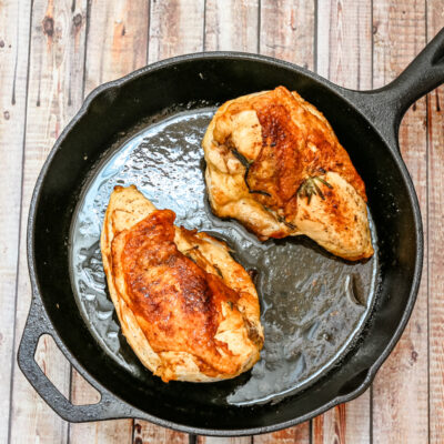 Herb roasted split chicken breasts in a cast iron pan
