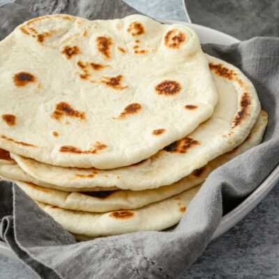 homemade naan bread on a kitchen towel.