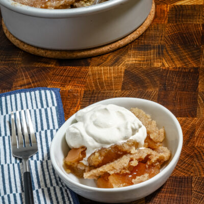 A warm serving of Instant Pot apple dump cake with whipped cream.