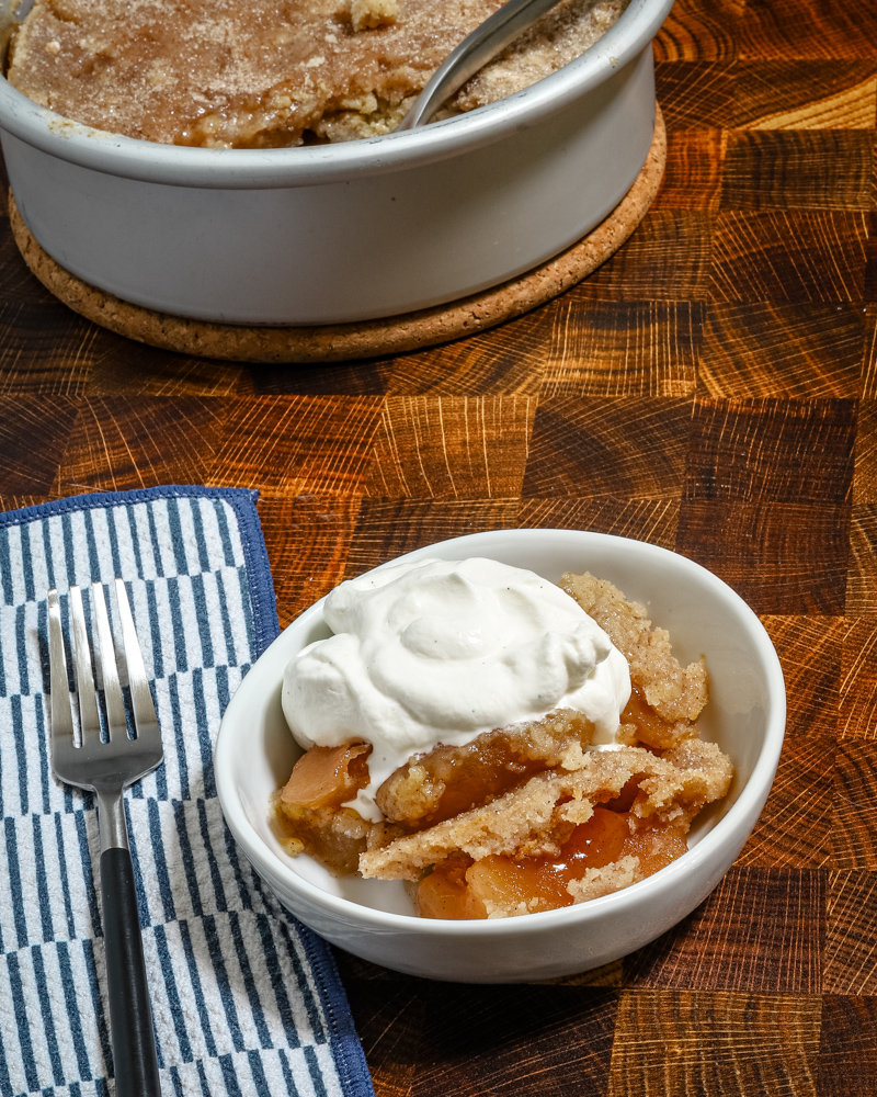 A warm serving of Instant Pot apple dump cake with whipped cream.