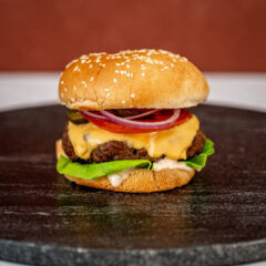 Instant Pot burger in a sesame seed bun with cheese and toppings.