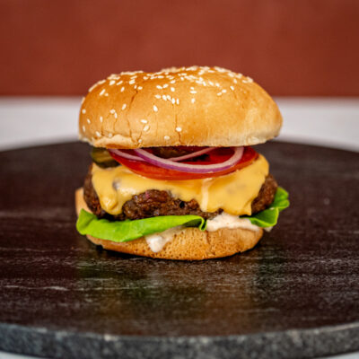 Instant Pot burger in a sesame seed bun with cheese and toppings.
