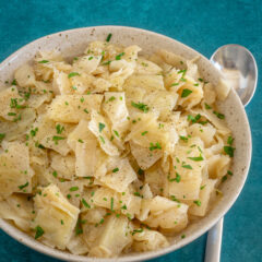 A serving bowl with Instant Pot cooked cabbage, garnished with parsley.