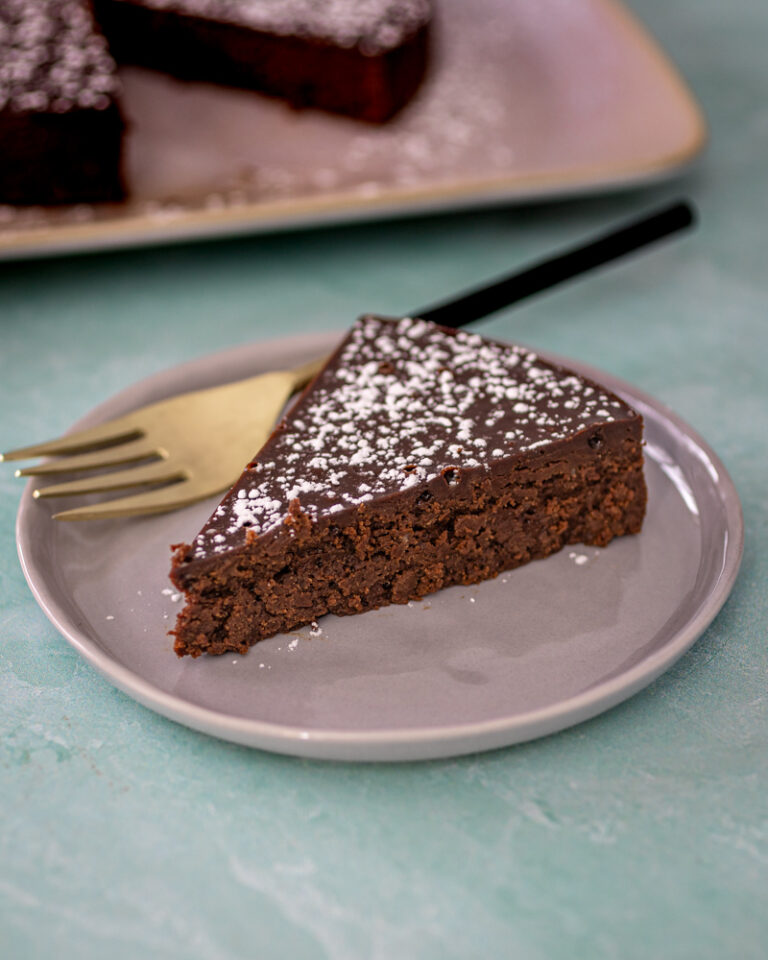 Rich chocolate truffle cake with powdered sugar on top.