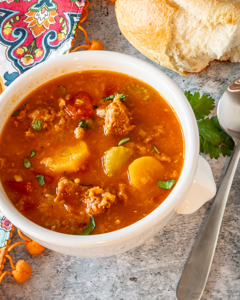 Chorizo and lentil soup from the Instant Pot, shown with crusty bread and cilantro garnish