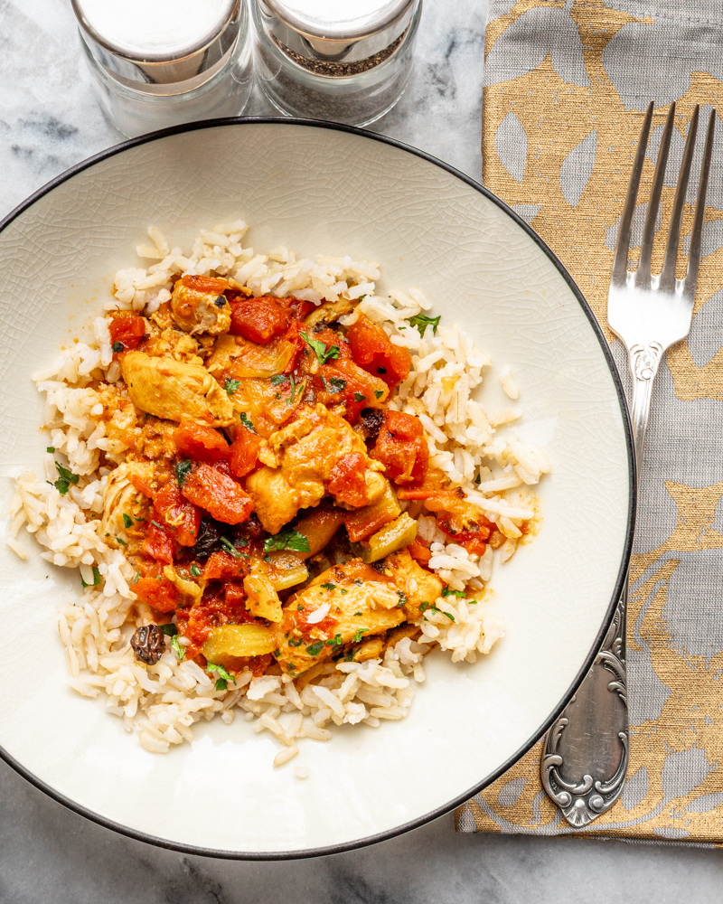 Country captain chicken in a bowl with rice.