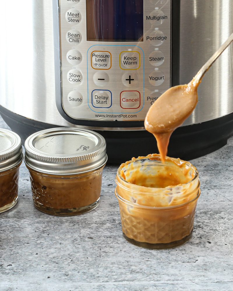 Instant Pot dulce de leche in jars for storage.