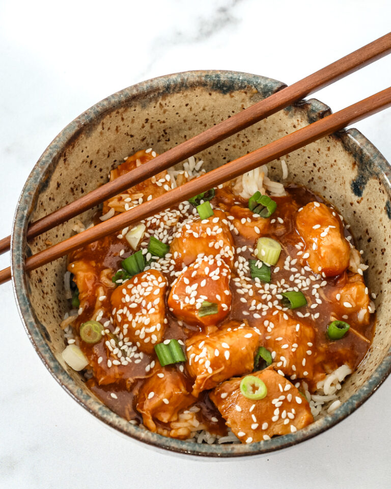 General Tso's chicken in a bowl with chopsticks.
