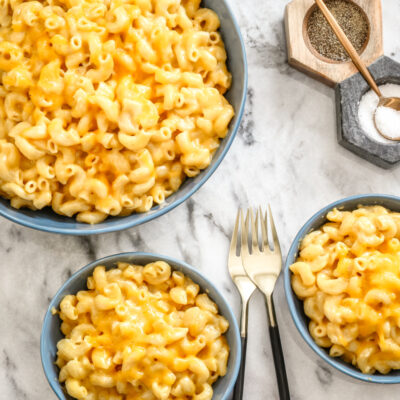 Instant Pot macaroni and cheese in bowls with forks on the side.