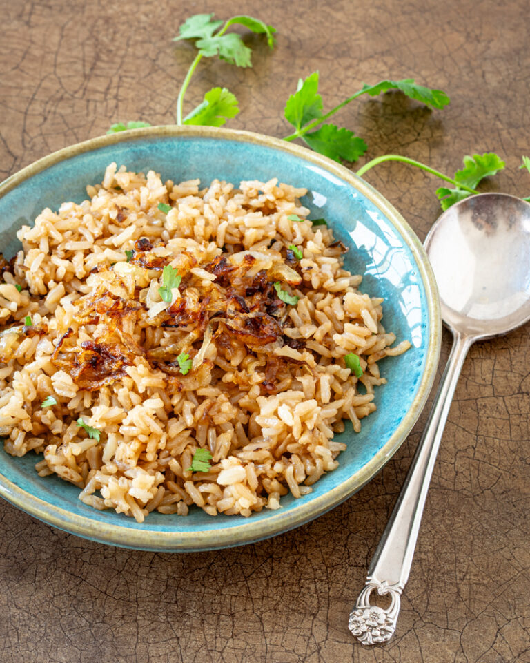 Parsi rice in a small bowl with spoon and cilantro.
