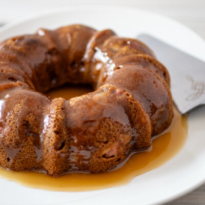 A pear cake on a large plate with glaze.