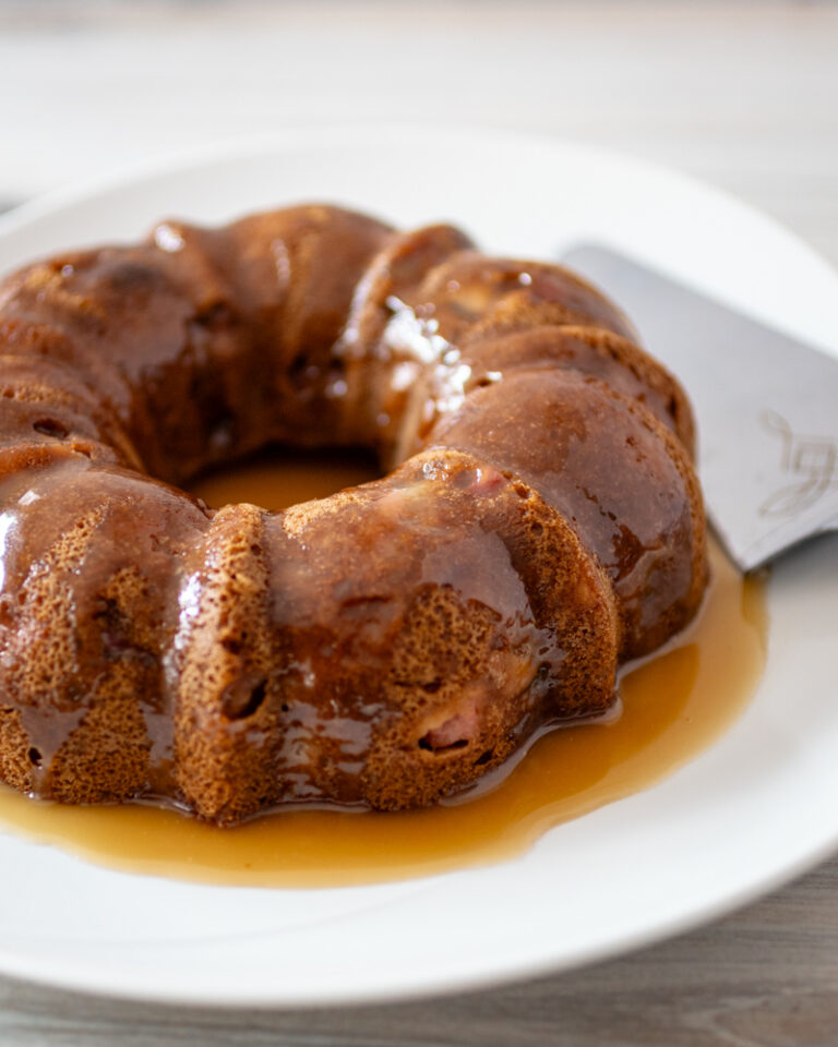 A pear cake on a large plate with glaze.