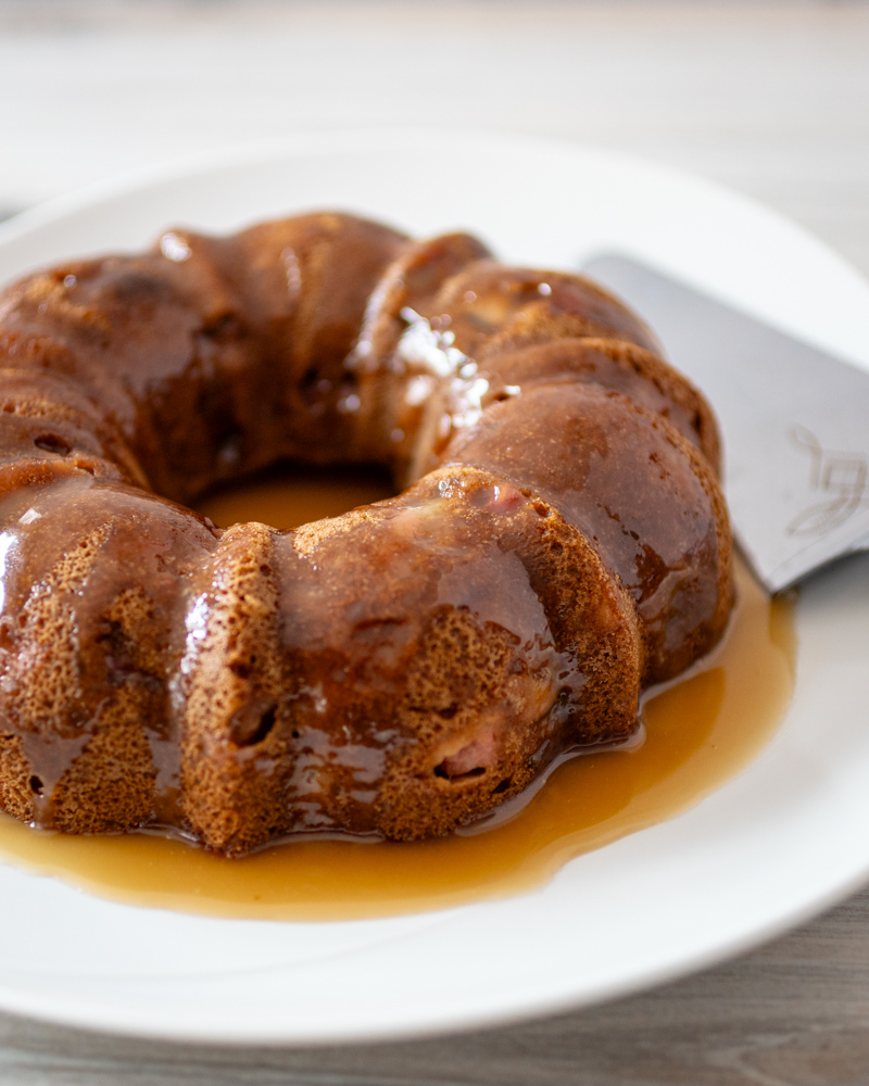 A pear cake on a large plate with glaze.