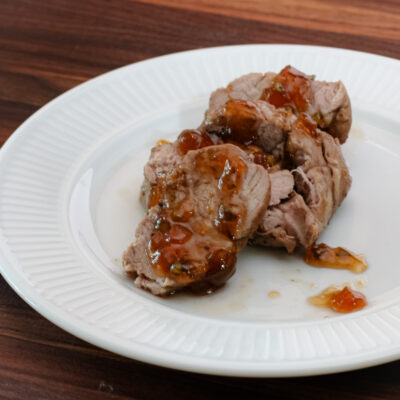 roasted pork tenderloin with jalapeño pepper glaze on a plate, sliced