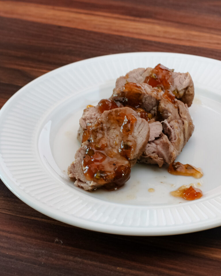 roasted pork tenderloin with jalapeño pepper glaze on a plate, sliced