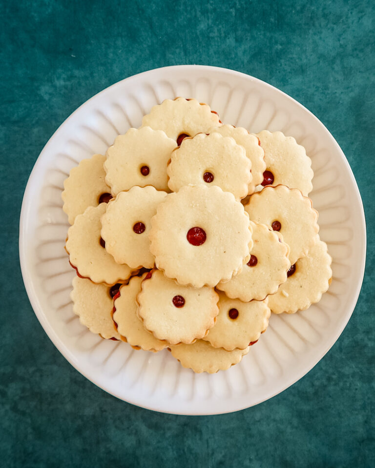 A plate of baked jammie dodgers filled with raspberry jam.