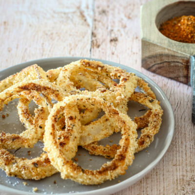keto onion rings on a plate with salt and pepper on the side.