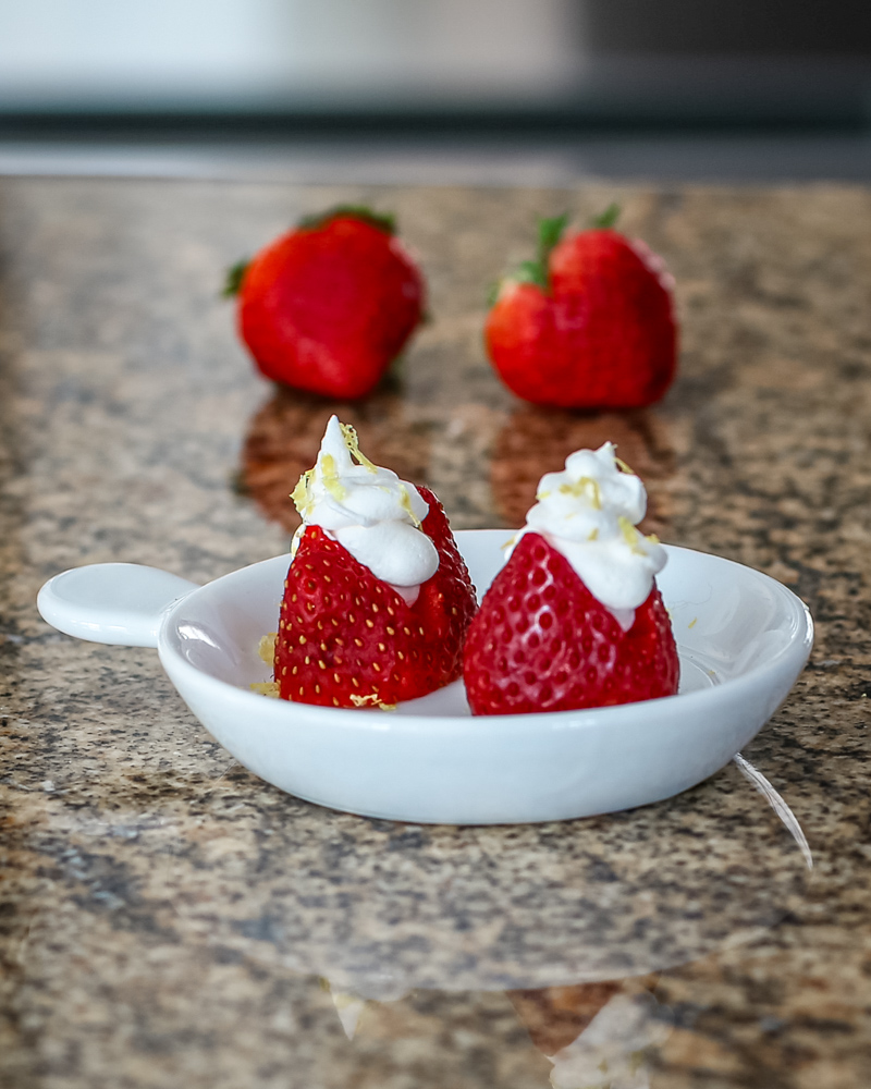 Lemon and cream cheese filled strawberries in a small appetizer dish.