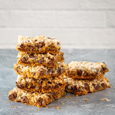 baked magic cookie bars on parchment paper, sliced