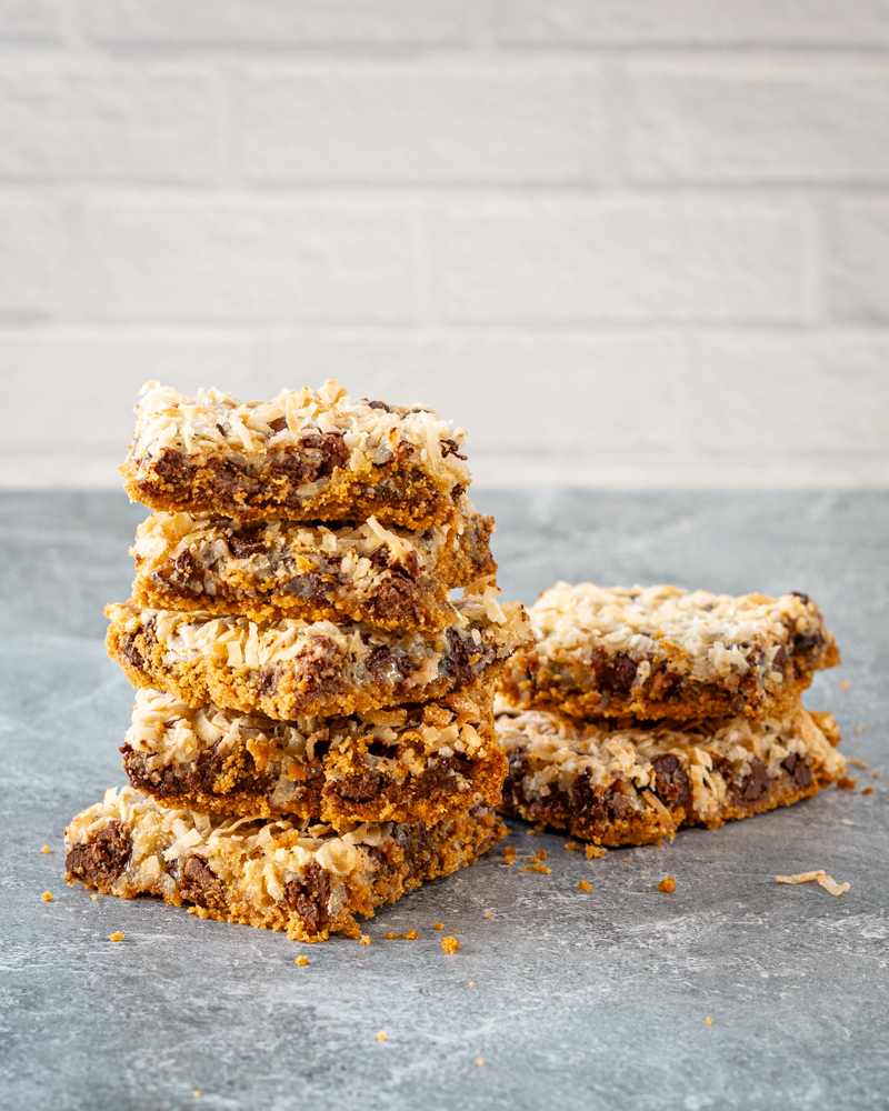 baked magic cookie bars on parchment paper, sliced