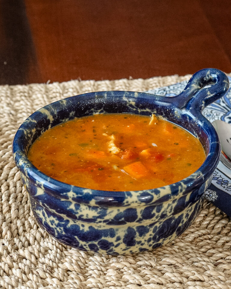 Warm bowl of mulligatawny soup in a decorative blue and white ceramic dish.