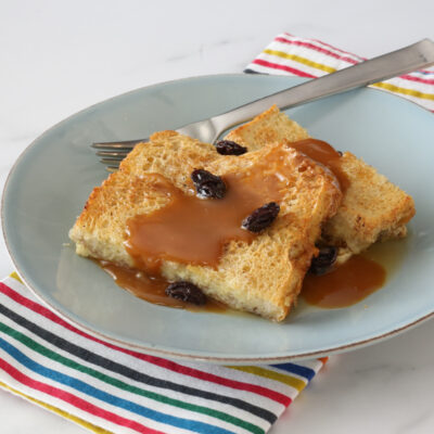 old-fashioned bread pudding on a plate with caramel sauce